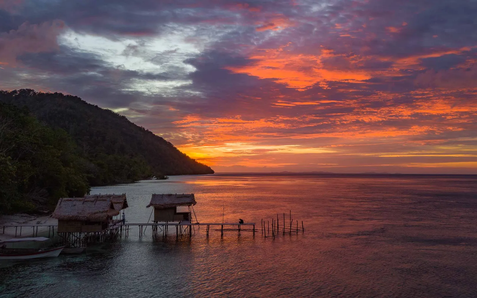 Sunset behind the homestays overwater bungalows on Batanta