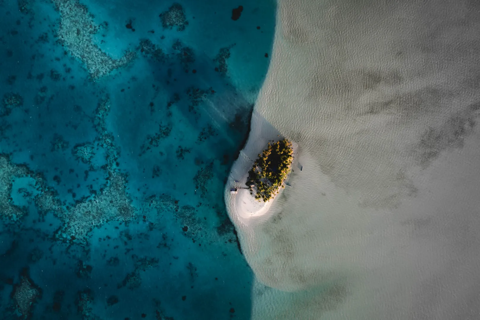 Tiny tropical island surrounded by crystal-clear water in Ayau, Raja Ampat