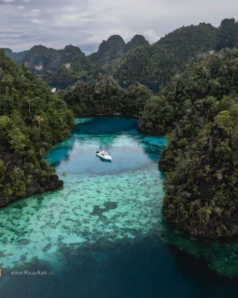 Shades of Misool: Deep blues, glowing shallows, ancient stone rising from the sea.