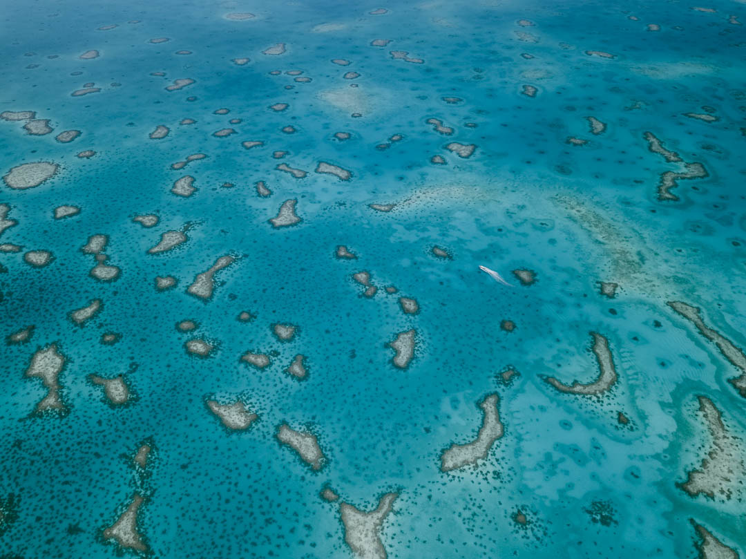 Aerial view of our boat cruising through Ayau's breathtaking lagoon in Raja Ampat