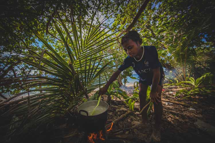 Outdoor cooking with fire and palm leaves